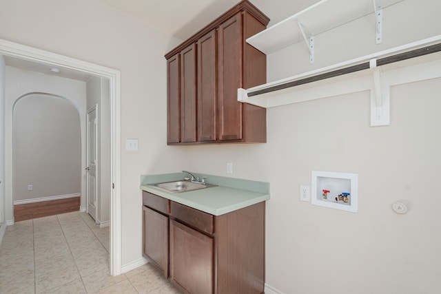 laundry area featuring light tile patterned flooring, sink, washer hookup, and cabinets