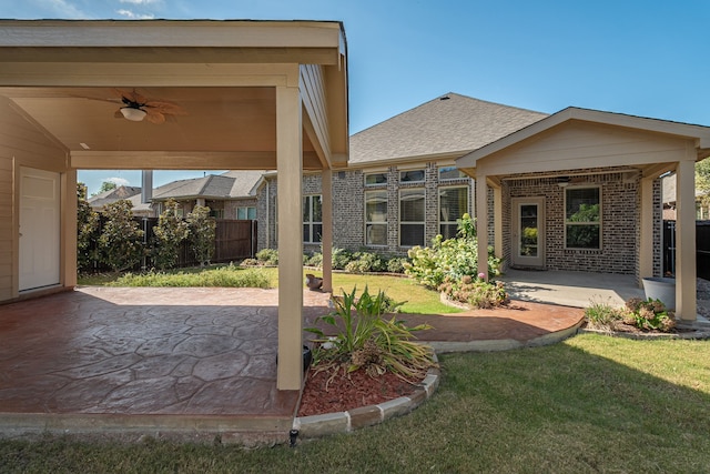 back of property with a patio, a lawn, and ceiling fan