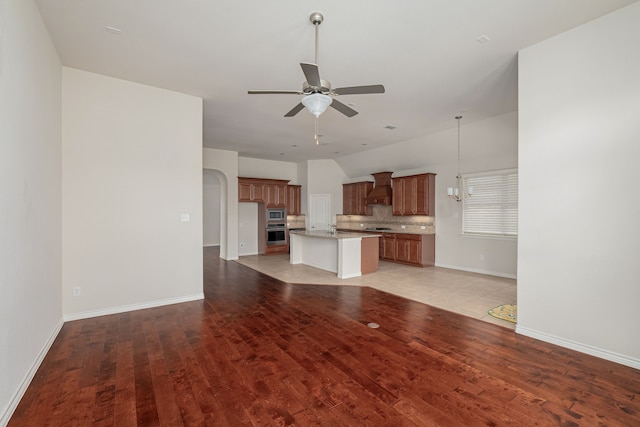 unfurnished living room with light hardwood / wood-style floors, sink, and ceiling fan