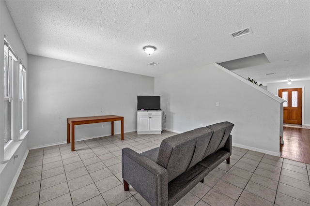 tiled living room with a textured ceiling