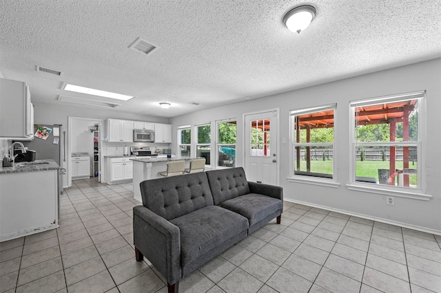 tiled living room with a textured ceiling and a healthy amount of sunlight