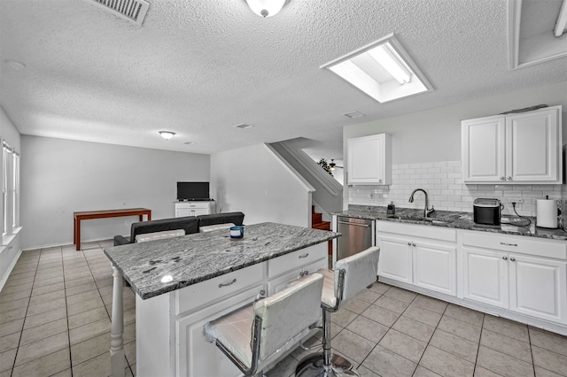 kitchen with sink, white cabinetry, decorative backsplash, and light tile patterned floors