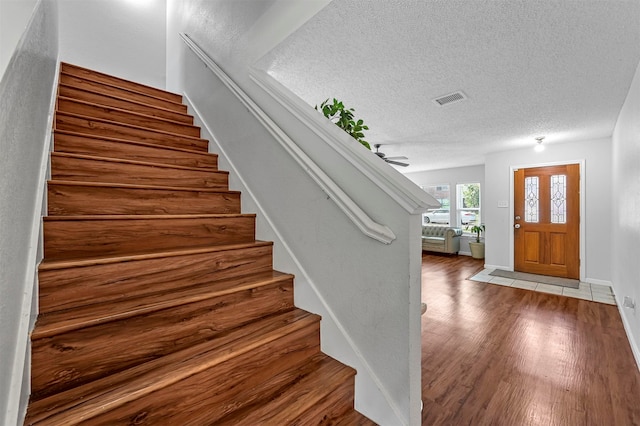 entryway with a textured ceiling and hardwood / wood-style floors