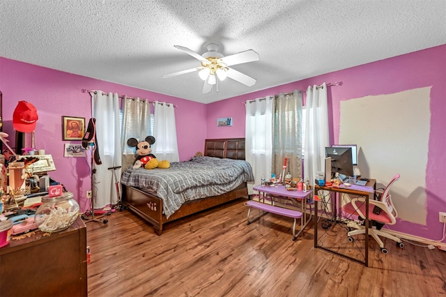 bedroom featuring wood-type flooring, a textured ceiling, and ceiling fan