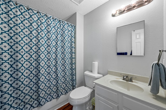 bathroom with vanity, a textured ceiling, and toilet