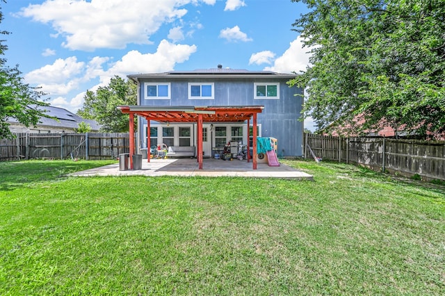 back of property with a pergola, a patio area, and a lawn