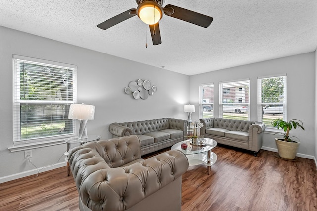 living room with a textured ceiling, ceiling fan, and hardwood / wood-style floors