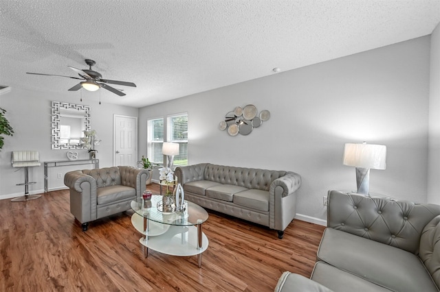 living room with a textured ceiling, ceiling fan, and hardwood / wood-style floors