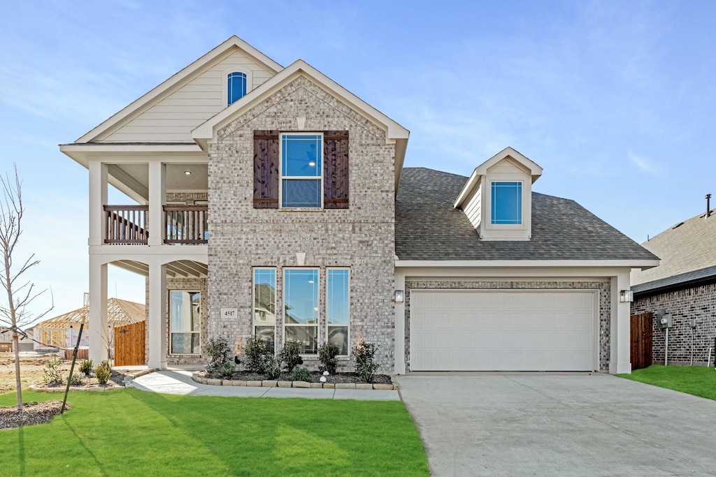 view of front facade with a garage, a balcony, and a front lawn