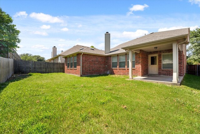 rear view of house with a yard and a patio area