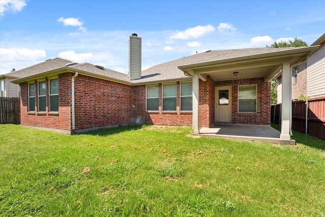 rear view of house with a patio area and a lawn