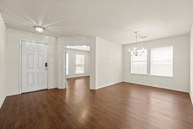 unfurnished living room with wood-type flooring and a chandelier