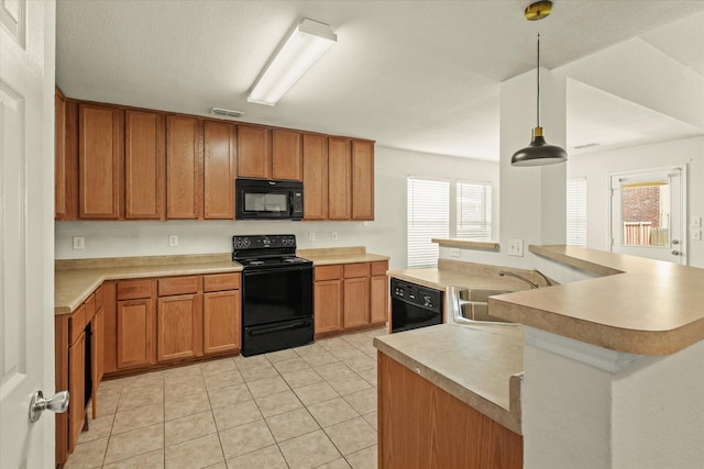 kitchen with light tile patterned floors, kitchen peninsula, black appliances, decorative light fixtures, and sink