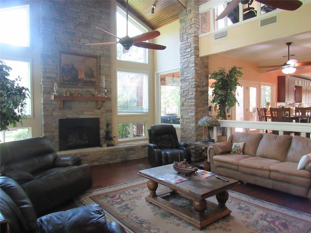 living room with a fireplace, ceiling fan, hardwood / wood-style floors, and high vaulted ceiling