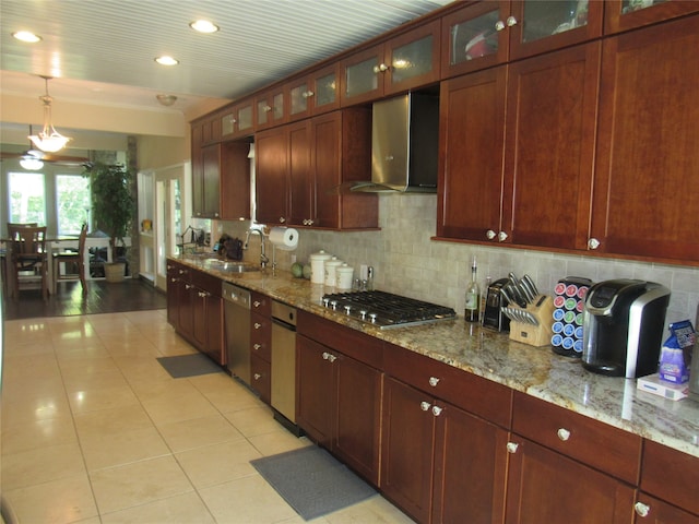 kitchen with light stone countertops, sink, wall chimney range hood, backsplash, and appliances with stainless steel finishes