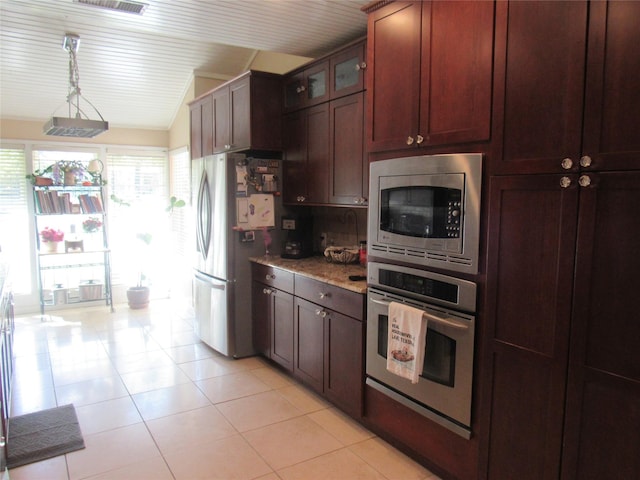 kitchen featuring stainless steel appliances, tasteful backsplash, stone countertops, glass insert cabinets, and light tile patterned flooring