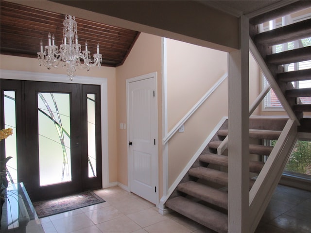 tiled entryway featuring lofted ceiling, wooden ceiling, and a notable chandelier