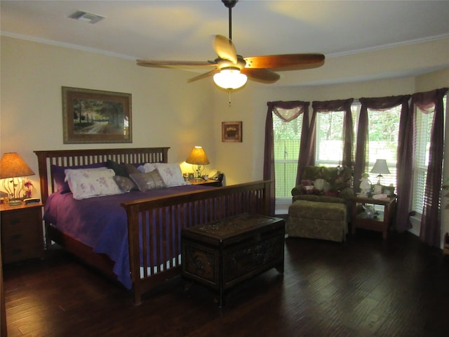 bedroom featuring dark hardwood / wood-style floors, ceiling fan, and crown molding