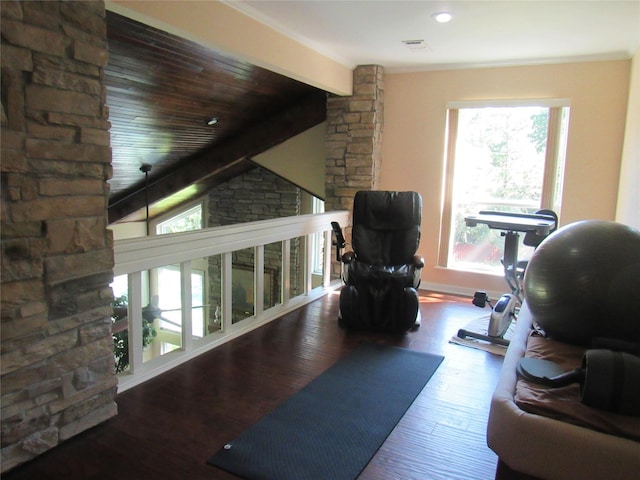 workout area featuring visible vents, vaulted ceiling, baseboards, and wood finished floors