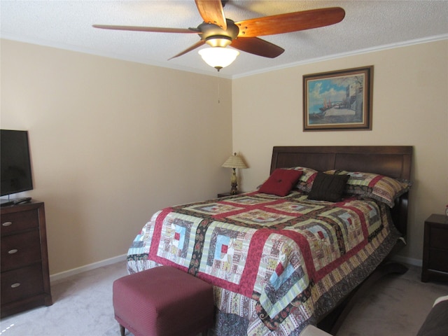 bedroom featuring a textured ceiling, light colored carpet, ceiling fan, and ornamental molding