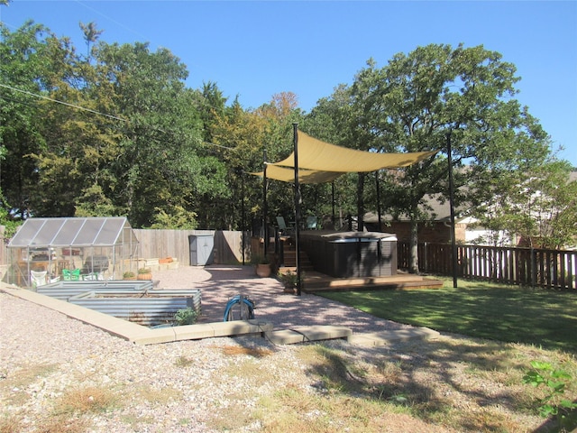 view of yard with an outbuilding, an exterior structure, a jacuzzi, and a fenced backyard