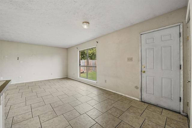 tiled foyer entrance featuring a textured ceiling