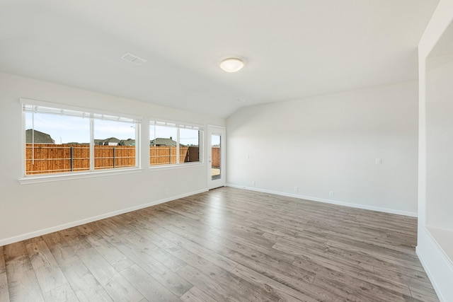 unfurnished room with wood-type flooring and lofted ceiling