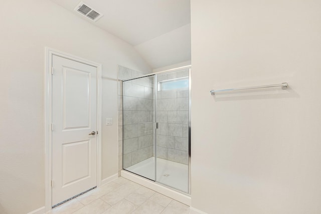 bathroom with a shower with shower door and vaulted ceiling