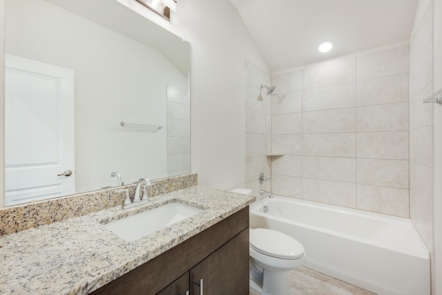 full bathroom with tiled shower / bath, vaulted ceiling, vanity, and toilet