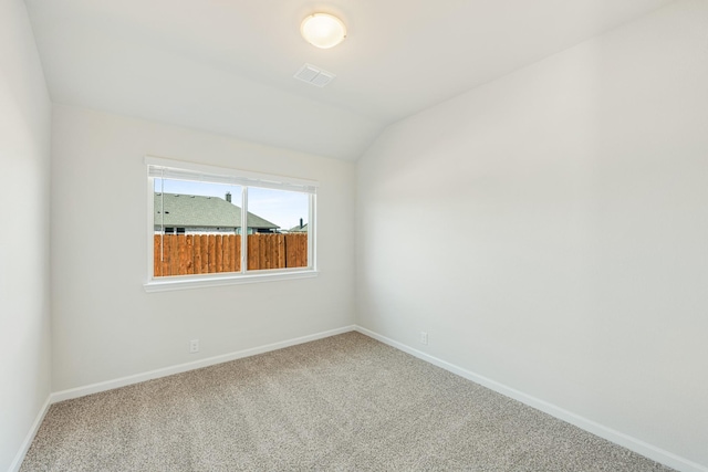 spare room with vaulted ceiling and carpet