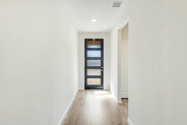 corridor with light hardwood / wood-style floors