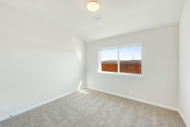 spare room featuring vaulted ceiling and carpet floors