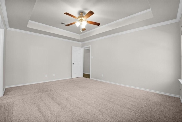 spare room featuring ornamental molding, a raised ceiling, ceiling fan, and carpet