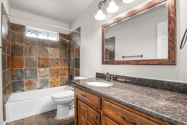 full bathroom featuring tiled shower / bath, vanity, and toilet