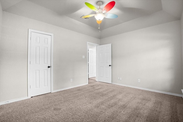 unfurnished bedroom featuring carpet flooring, ceiling fan, and a tray ceiling