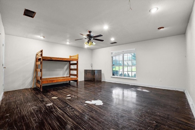 unfurnished bedroom featuring ceiling fan and dark hardwood / wood-style floors