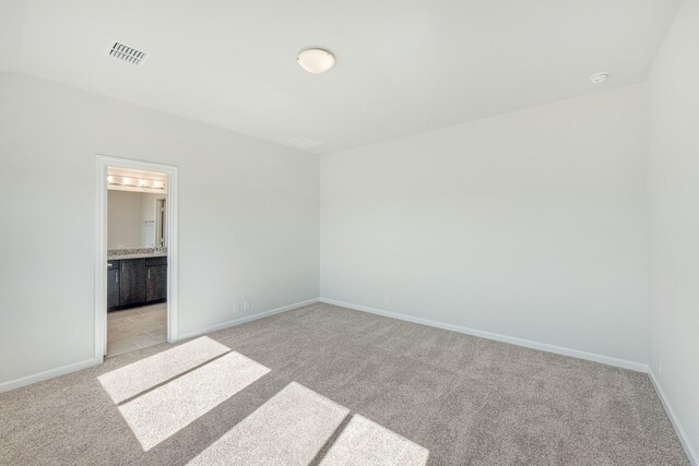 additional living space featuring light carpet, vaulted ceiling, and a textured ceiling