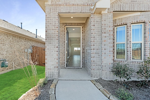 view of exterior entry featuring a lawn