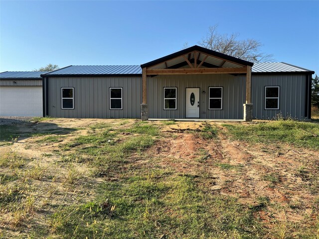 rear view of house featuring a garage and a lawn