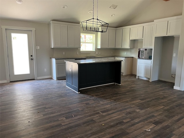 kitchen with white cabinetry, vaulted ceiling, hanging light fixtures, dark hardwood / wood-style flooring, and a kitchen island