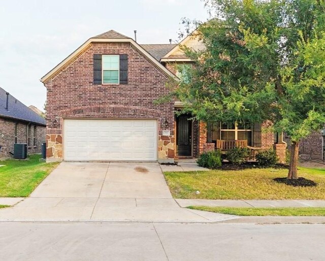 view of front property with a garage, a front lawn, and cooling unit