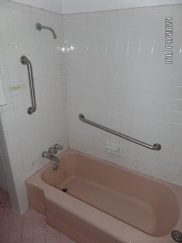 bathroom featuring tiled shower / bath combo and tile patterned flooring