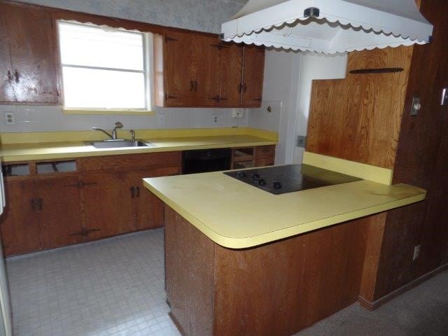 kitchen with black appliances, sink, and light tile patterned floors