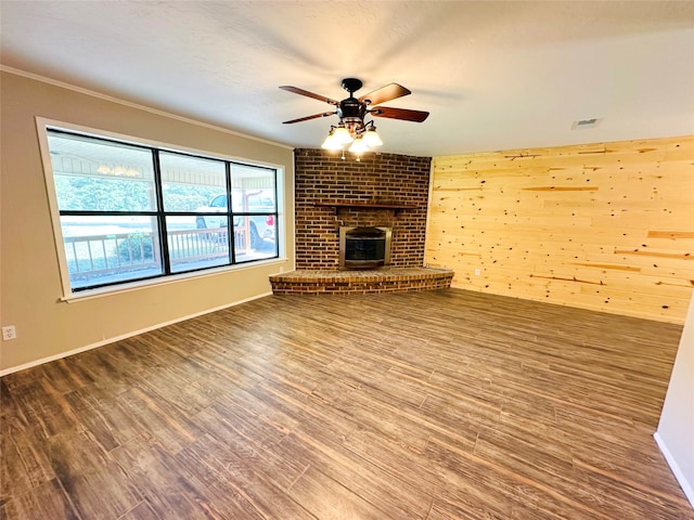 unfurnished living room featuring brick wall, a fireplace, and hardwood / wood-style floors