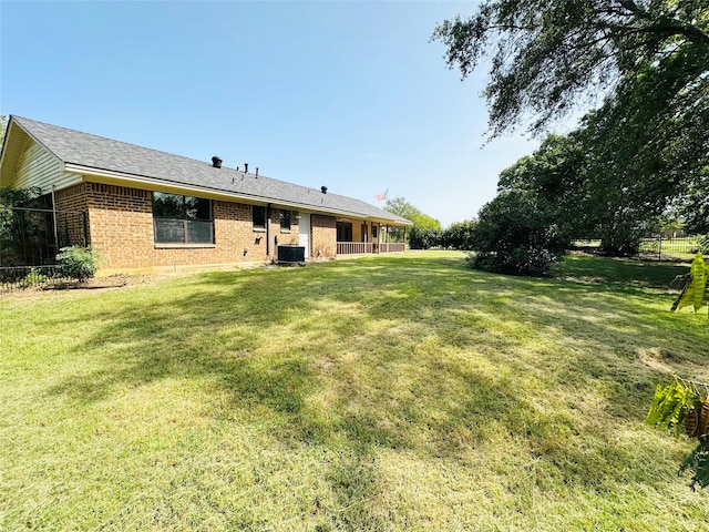 back of house featuring a yard and central AC