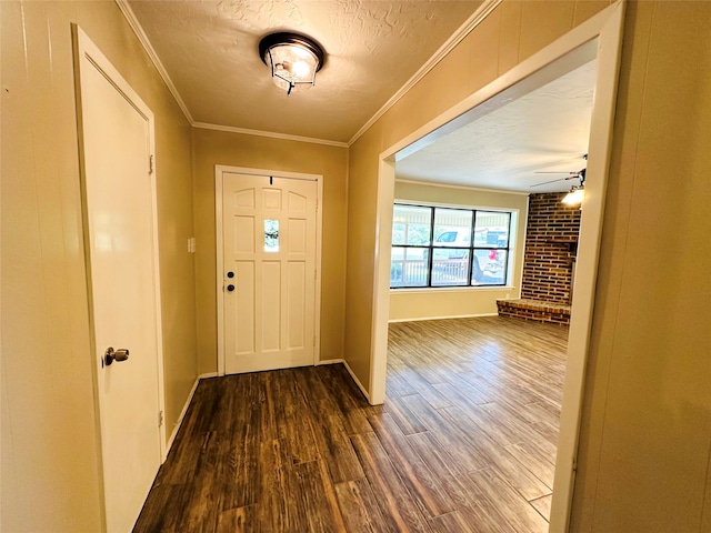 entryway with wood-type flooring, ceiling fan, ornamental molding, brick wall, and a textured ceiling