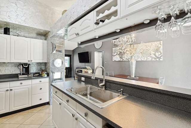 kitchen with sink, white cabinets, and light tile patterned flooring