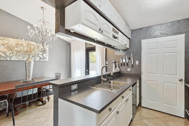 kitchen featuring kitchen peninsula, sink, light tile patterned floors, a textured ceiling, and white cabinets