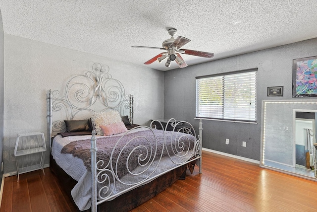 bedroom with ceiling fan, a textured ceiling, and hardwood / wood-style flooring