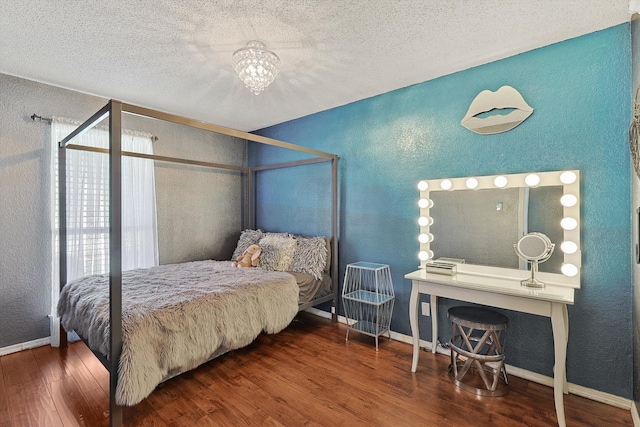 bedroom with a chandelier, a textured ceiling, and hardwood / wood-style flooring